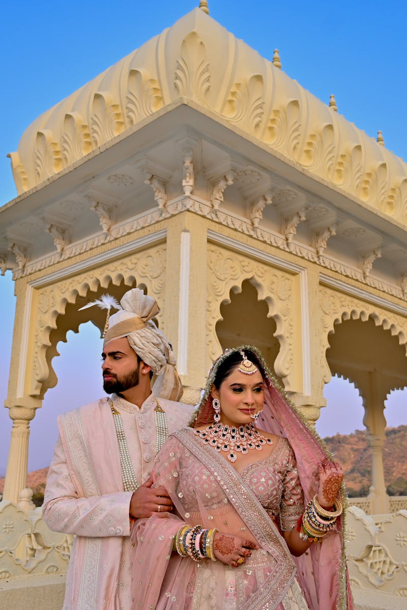 Stunning capture of an Indian bride and groom at a traditional palace setting, exuding elegance and cultural richness.